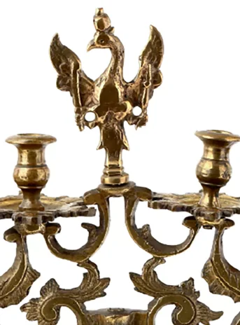 Decorative brass candlestick on a high leg with two places for candles.